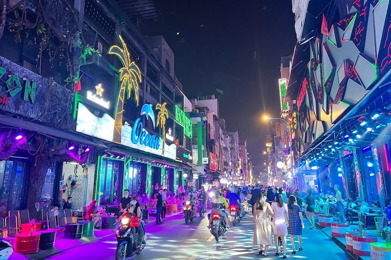 Bustling street life in Ho Chi Minh City with motorcycles and skyscrapers