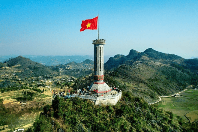 "Lung Cu Flag Tower in Ha Giang, Vietnam, with the red and gold Vietnamese flag."