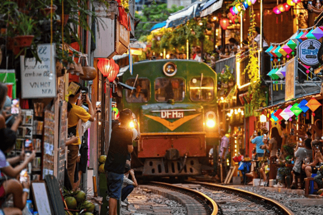 A train cutting through a narrow street market in Hanoi, Vietnam.