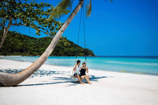 A sunny day at Phu Quoc beach with turquoise waters and palm trees.